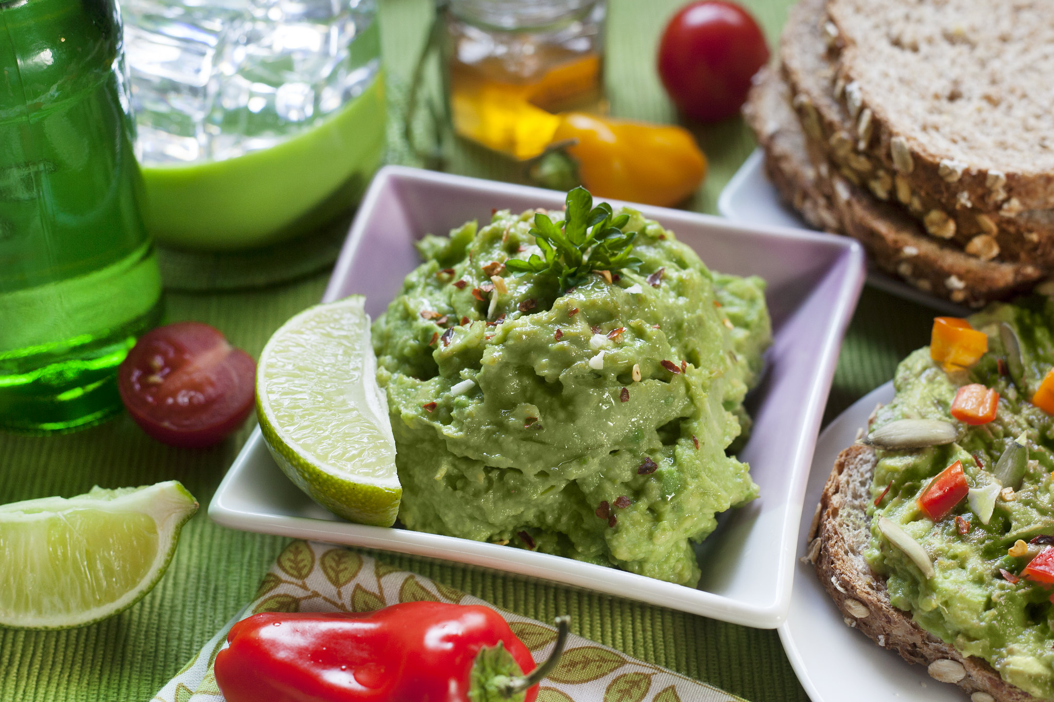 Bowl of guacamole amongst other foods.