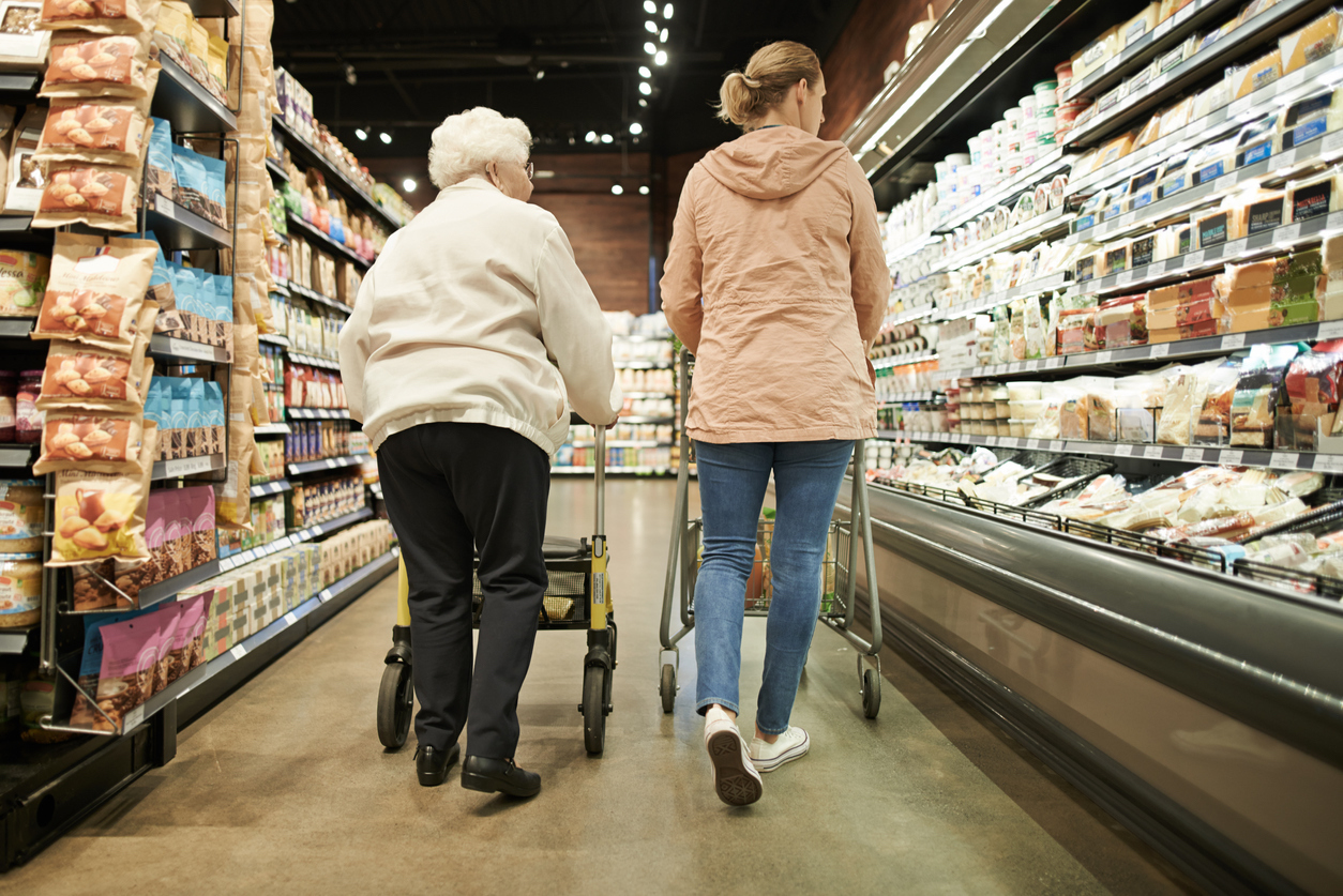 A senior woman shopping with her daughter at a grocery store