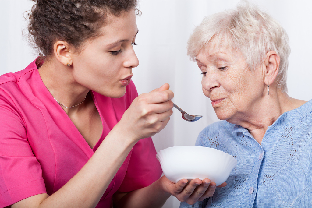 Nurse Feeding an Older Woman