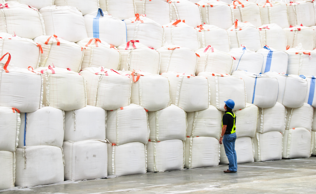 Supervisor inspecting huge sacks of sugar in a warehouse — sugar shortage November 2019