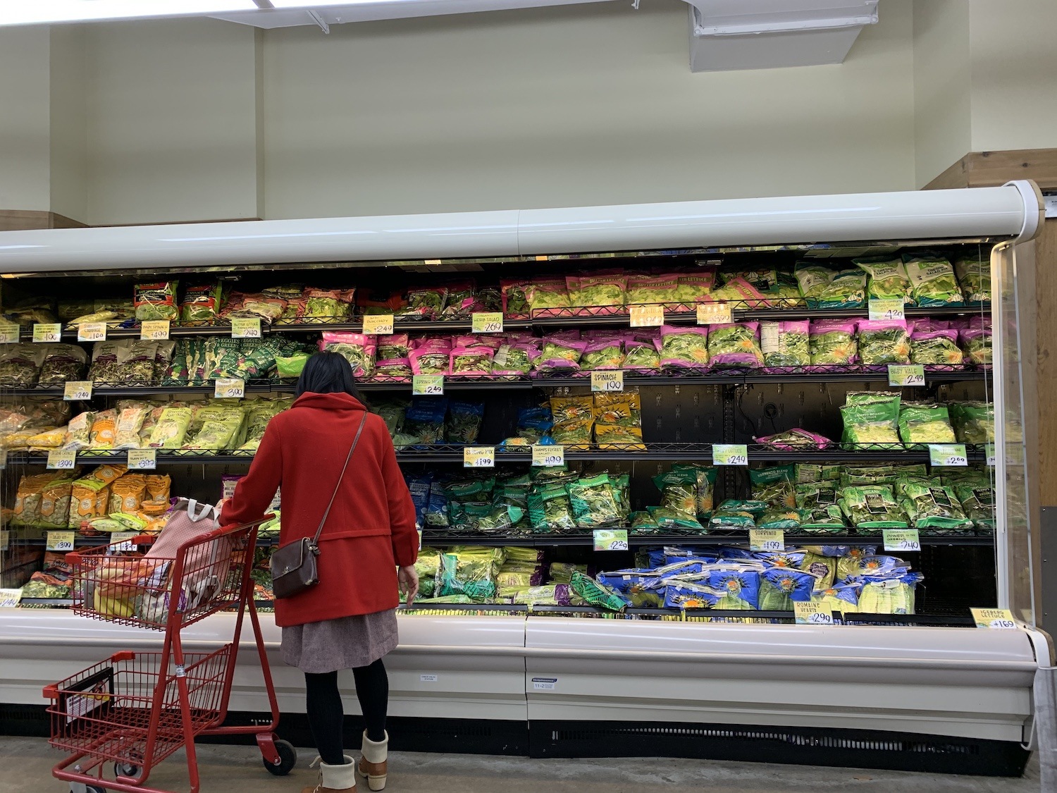 Shopper looking at leafy greens aisle at grocery store