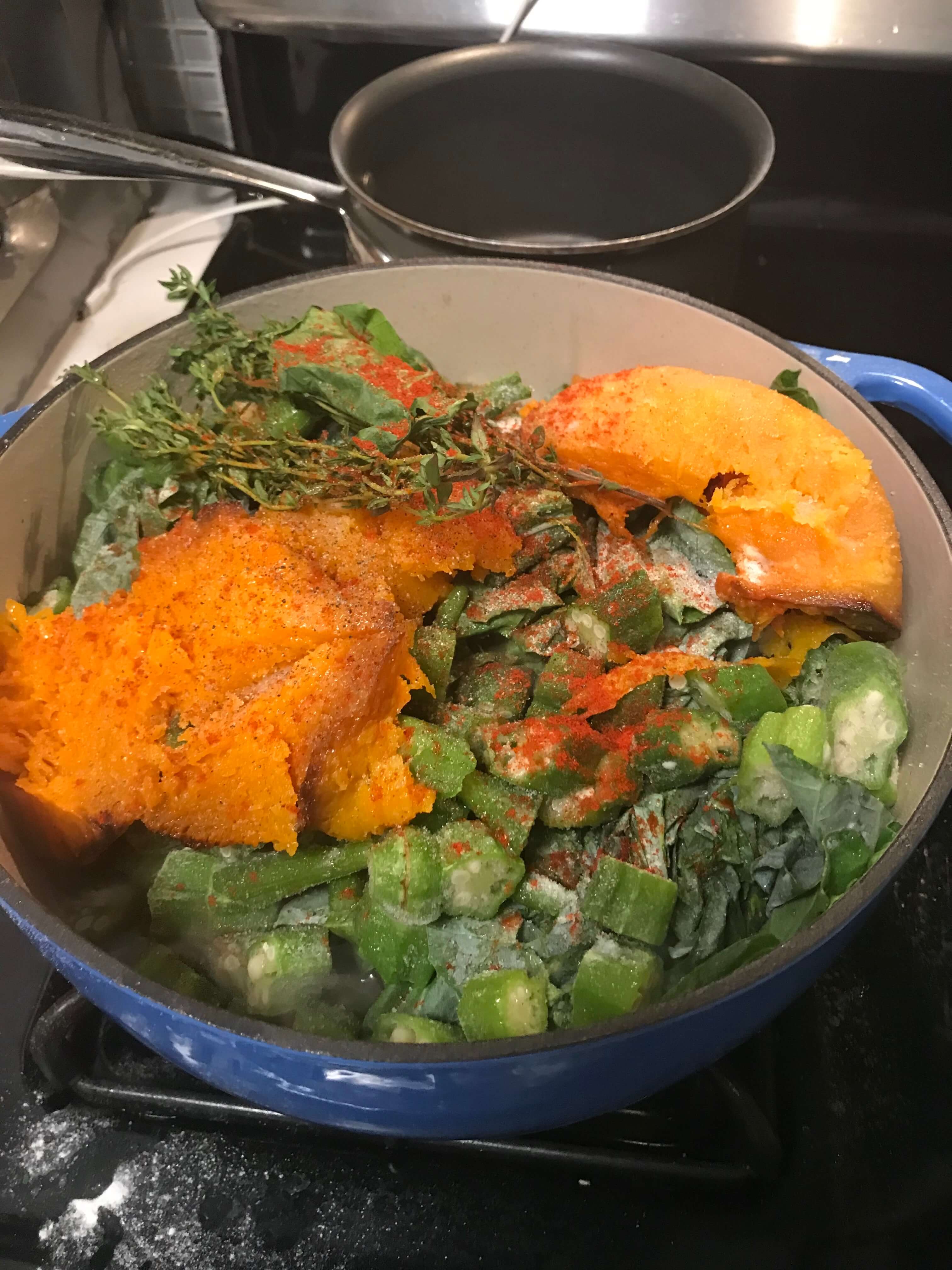 A pot with ingredients to make callaloo sits on top of the stove. April 2020