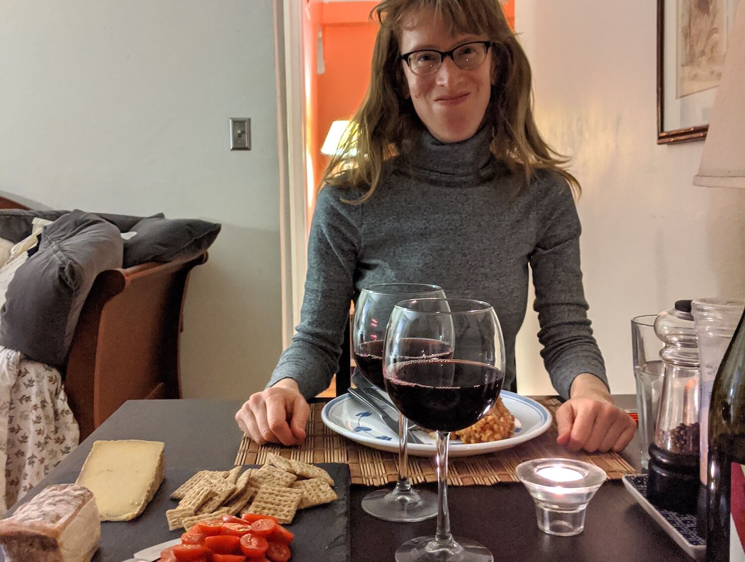 Kyle McCarthy at her home restaurant with barley risotto wine and cheese May 2020