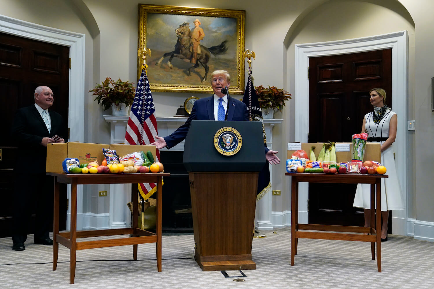 President Donald Trump speaks about the food supply chain during the coronavirus pandemic, in the Roosevelt Room of the White House, Tuesday, May 19, 2020, in Washington. Agriculture Secretary Sonny Perdue, left, and Ivanka Trump, the daughter of President Donald Trump, listen. (May 2020)