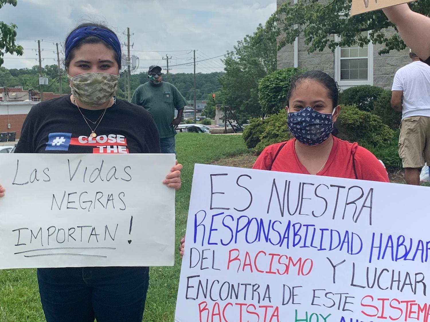 Two protesters stand with signs written entirely in Spanish, showing solidarity from all parts of the Silar City community. June 2020