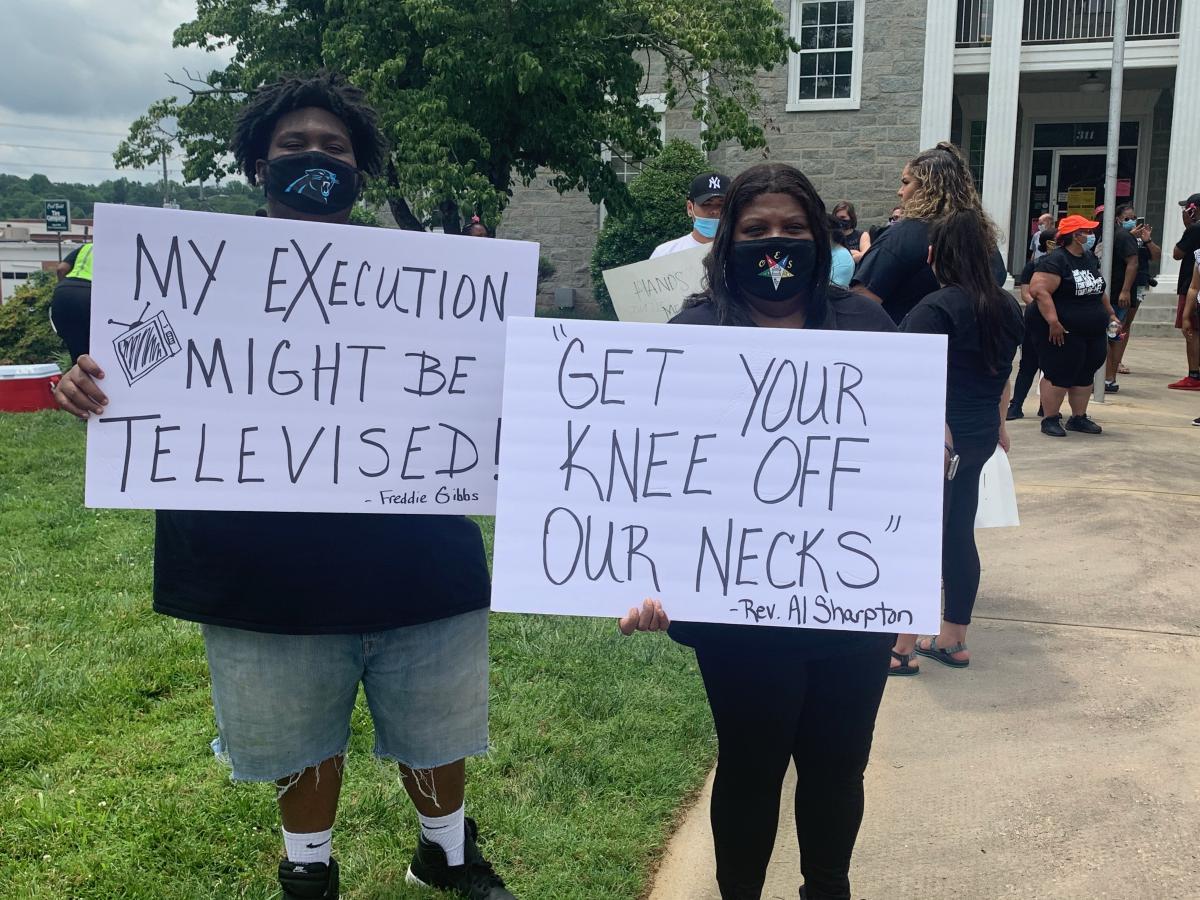 Two protesters holding signs that read 