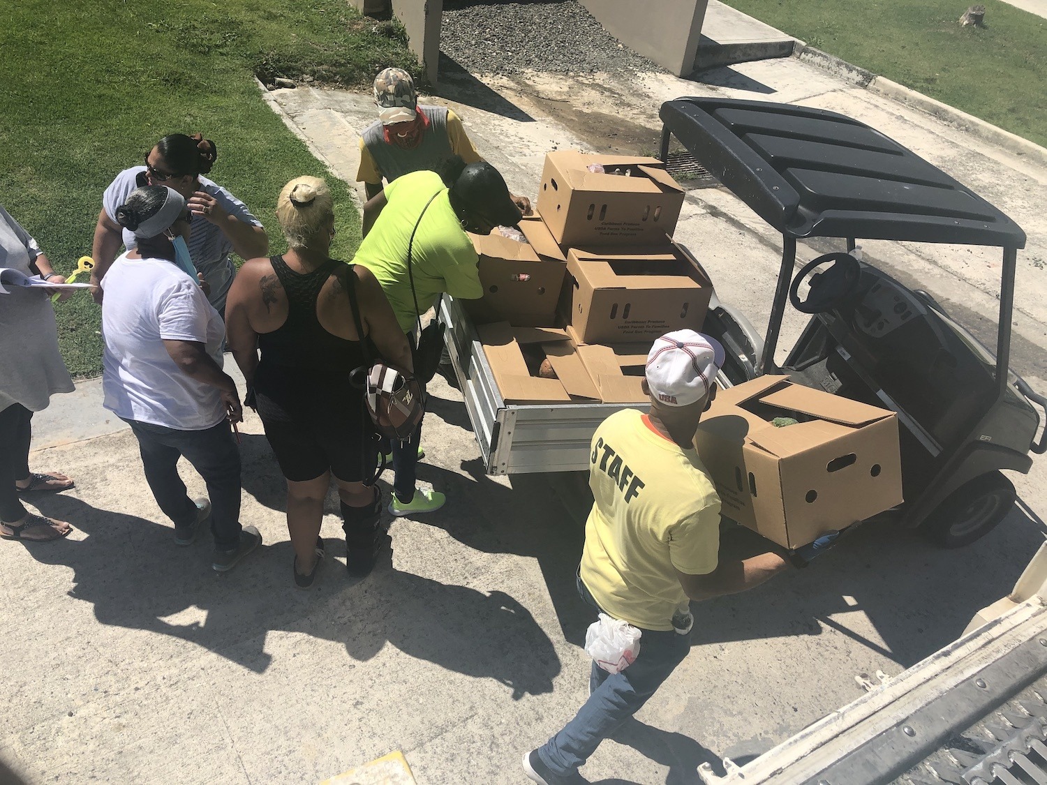 Volunteers load food boxes onto a golf cart to distribute in the Manuel A. Perez Housing Project June 2020