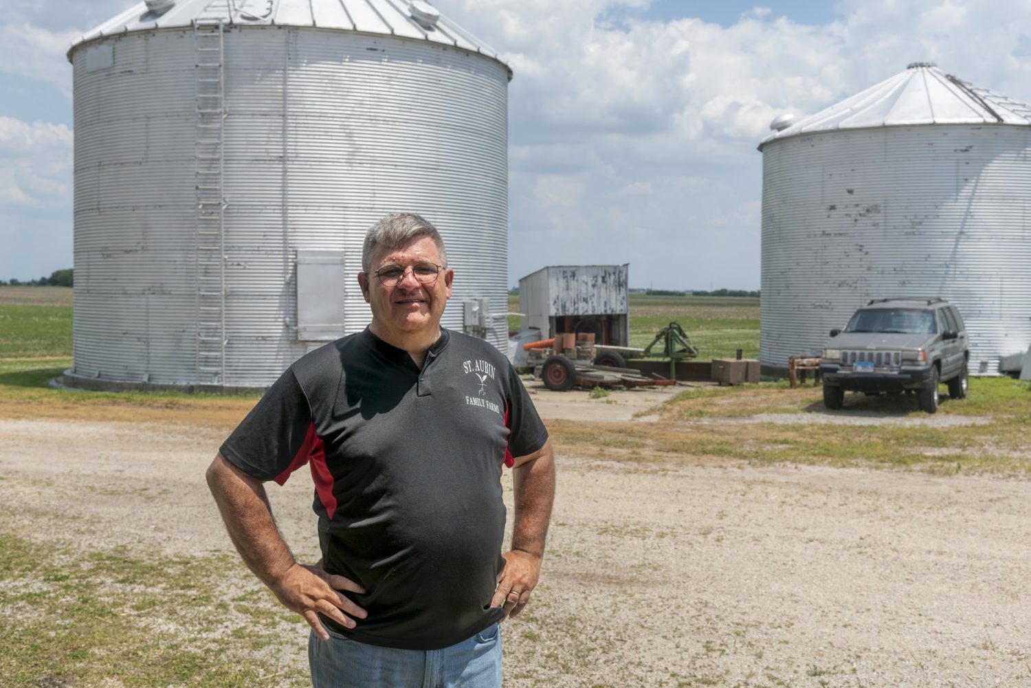 St. Albin stands, hands on hips, in front of two large silos on his Illinois farm. July 2020