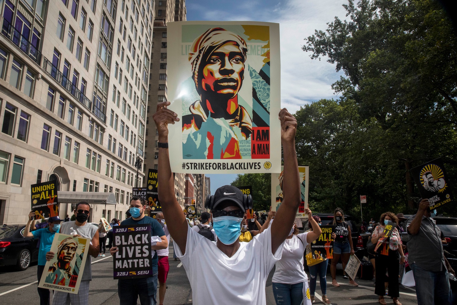 Protesters walk down Central Park West carrying signs for the Strike for Black Lives July 2020