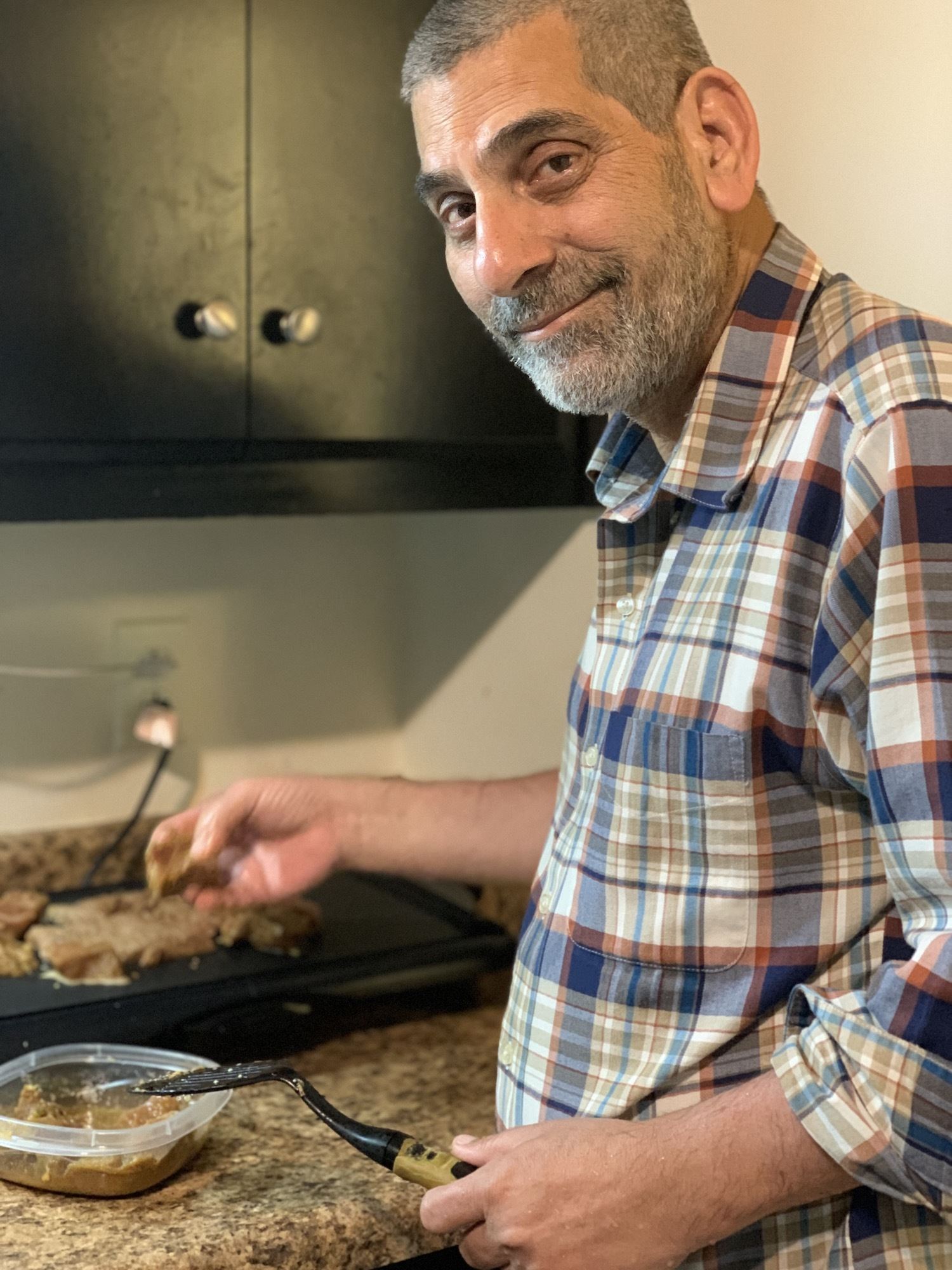 Syed Abidi holding a spatula while he cooks beef for dinner July 2020