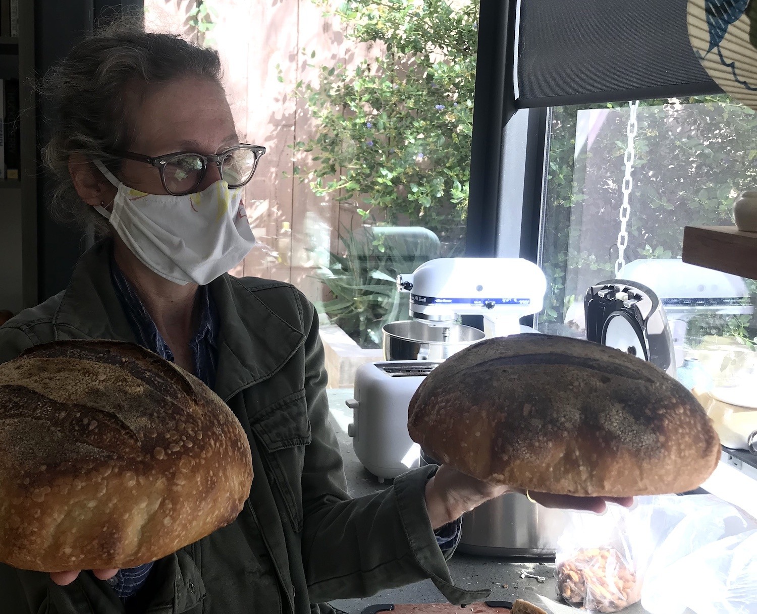 Isabel Adler's mother poses with two loaves of bread. August 2020