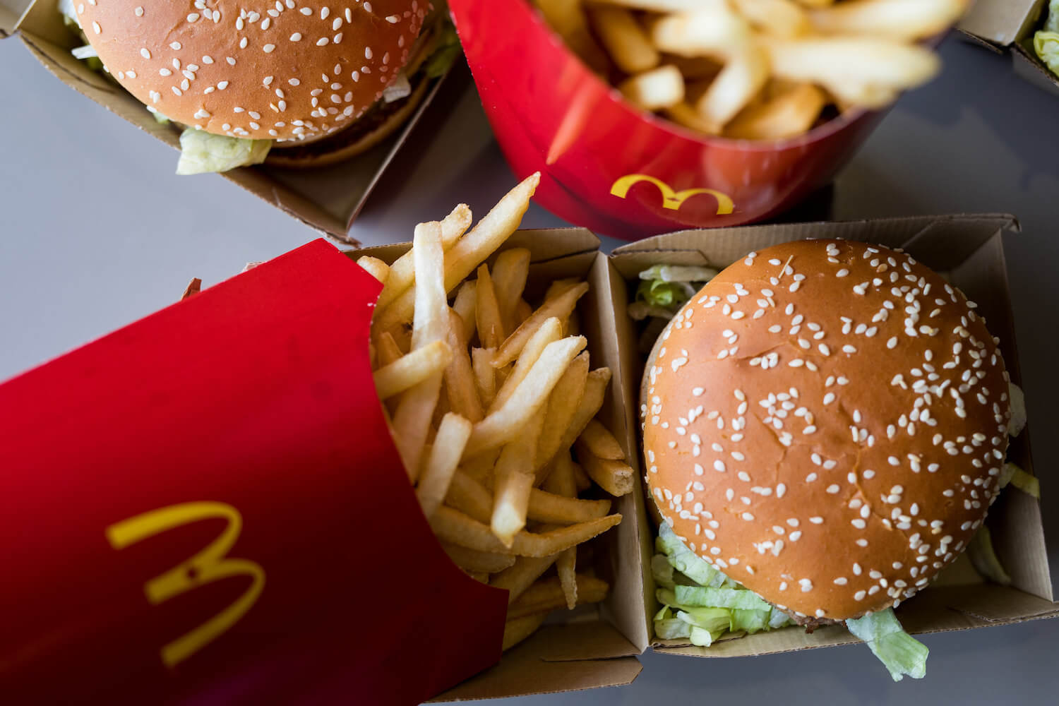 Overview shot of McDonald's fries and a Big Mac burger in their paper packaging. August 2020