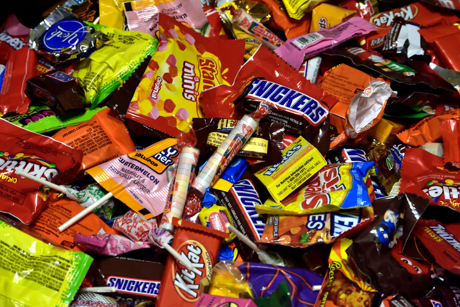 Overhead shot of various popular candy brand wrappers. September 2020