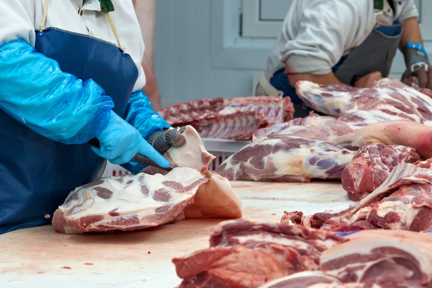 Butchers are cutting pork in the meat plant. September 2020