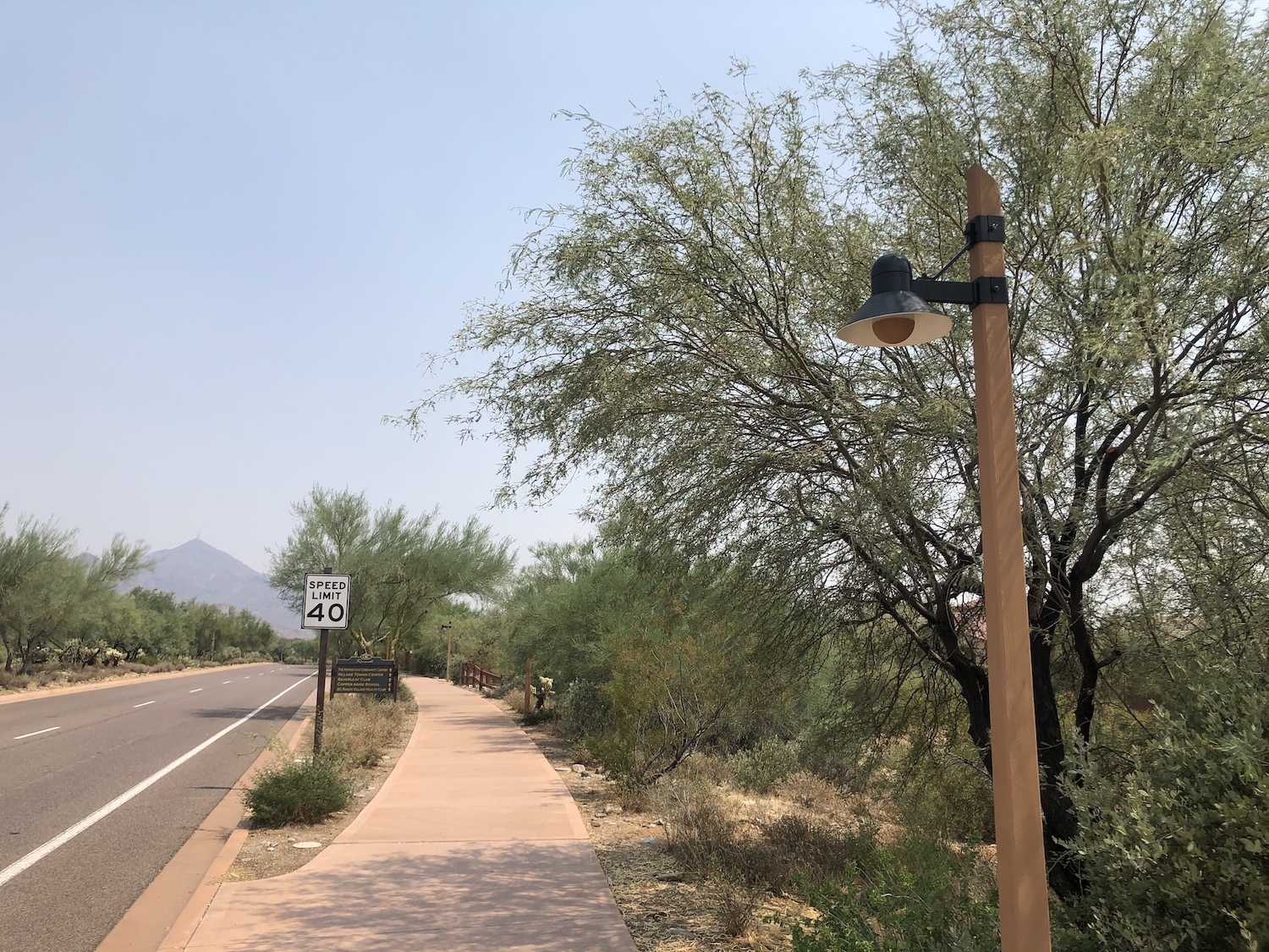 Sonoran Desert road with a 40-mile speed limit sign and street lamp. September 2020