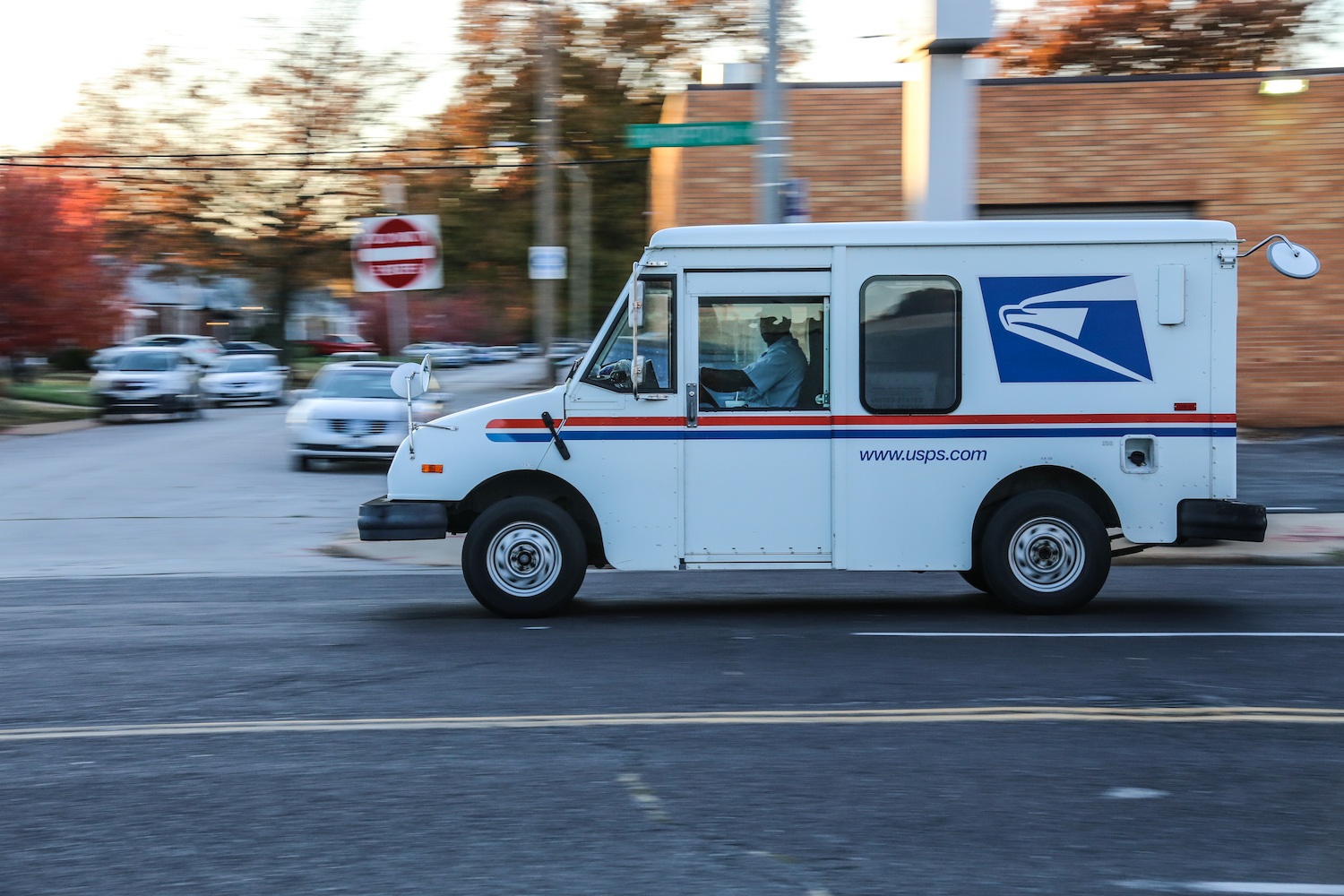 USPS truck drives down the road. October 2020