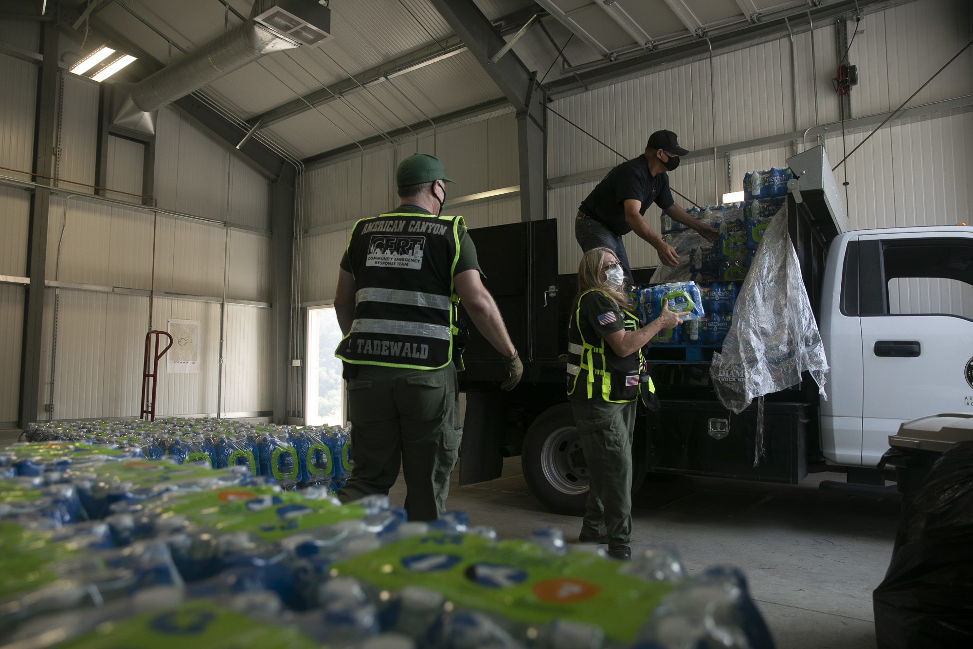 American Canyon CERT members Michael Tadewald, left, and Mary Tabbert unload cases of water at Berryessa Highlands’ fire department on Sept. 21, 2020. Thousands of gallons of water have been distributed to residents since early September. November 2020