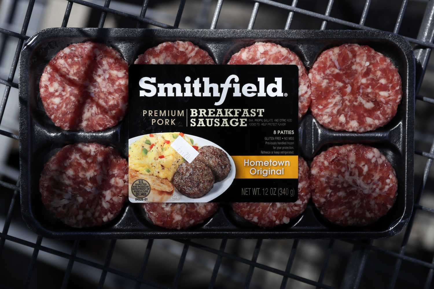In this April 14, 2020, photo, a package of Smithfield Foods breakfast sausage sits in a shopping cart outside of a local grocery story, in Des Moines, Iowa. The surge of coronavirus cases at Smithfield Foods in Sioux Falls, S.D. has highlighted the vulnerability of meat processing workers, who stand shoulder-to-shoulder on the line and congregate in crowded locker rooms and cafeterias.