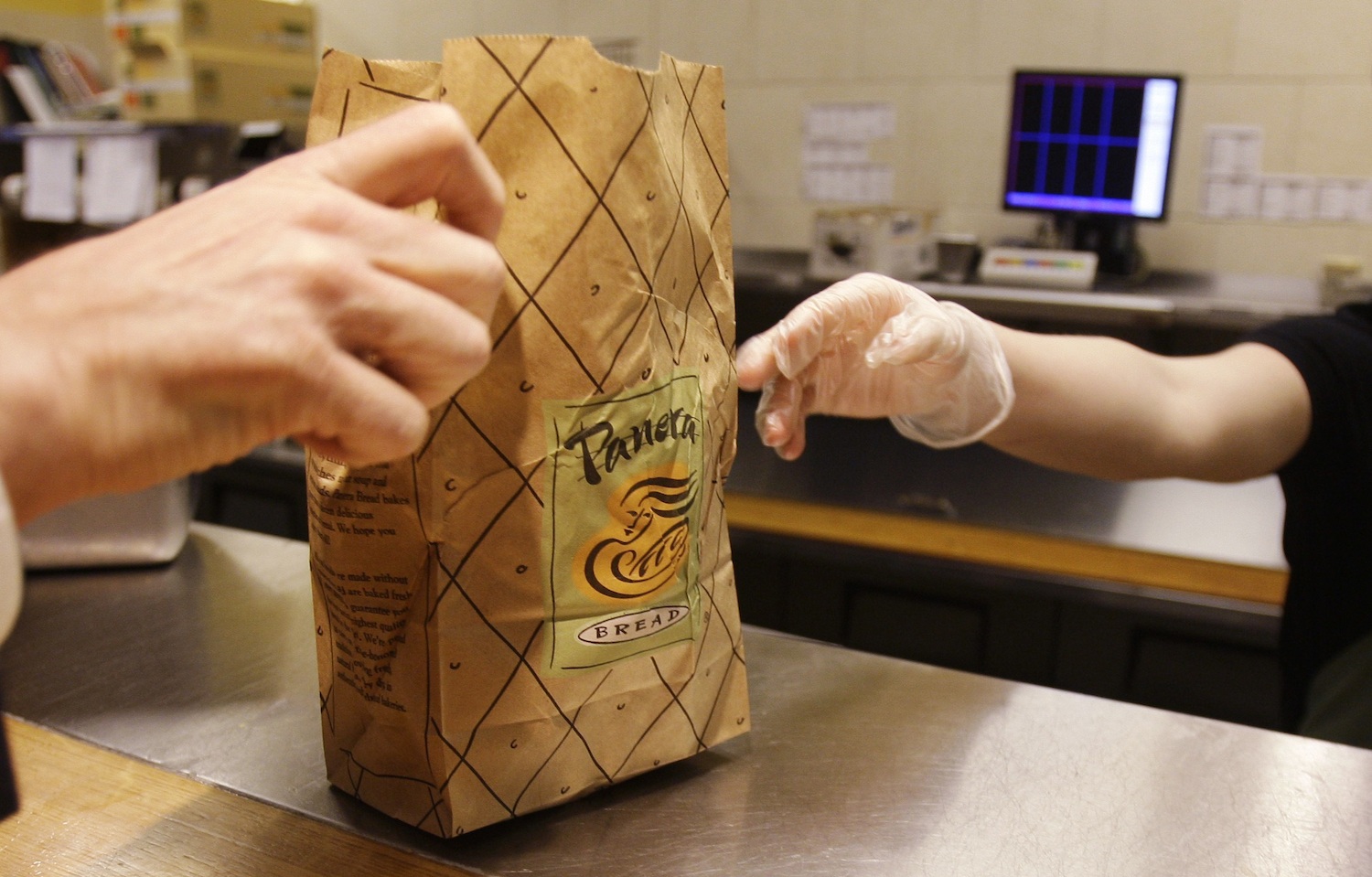In this March 8, 2010 file photo, Krista Johnson passes an order to a customer at a Panera Bread store in Brookline, Mass.