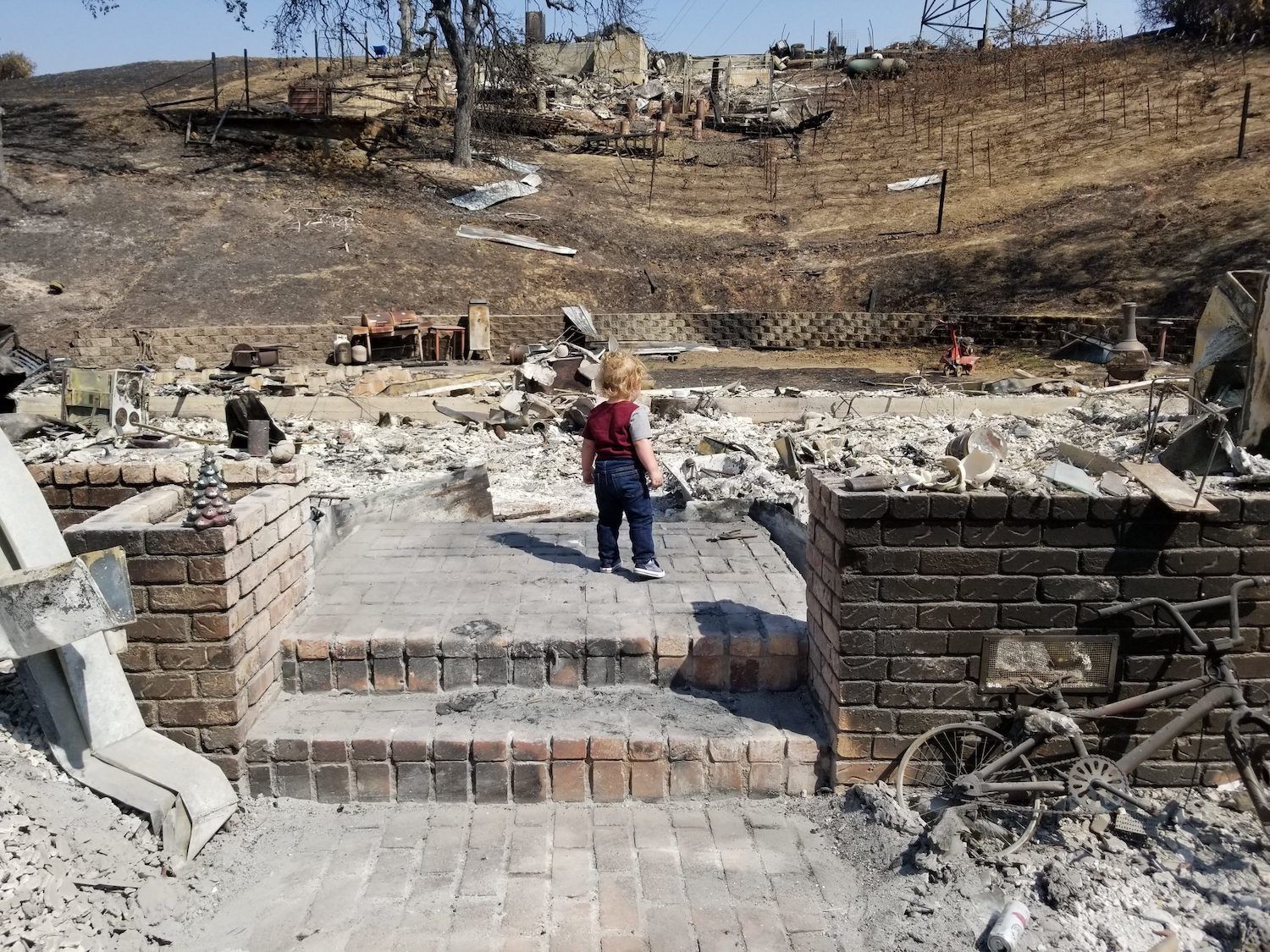 Levi Petrini stands in the ruins of his family’s burned Berryessa Highlands home. November 2020