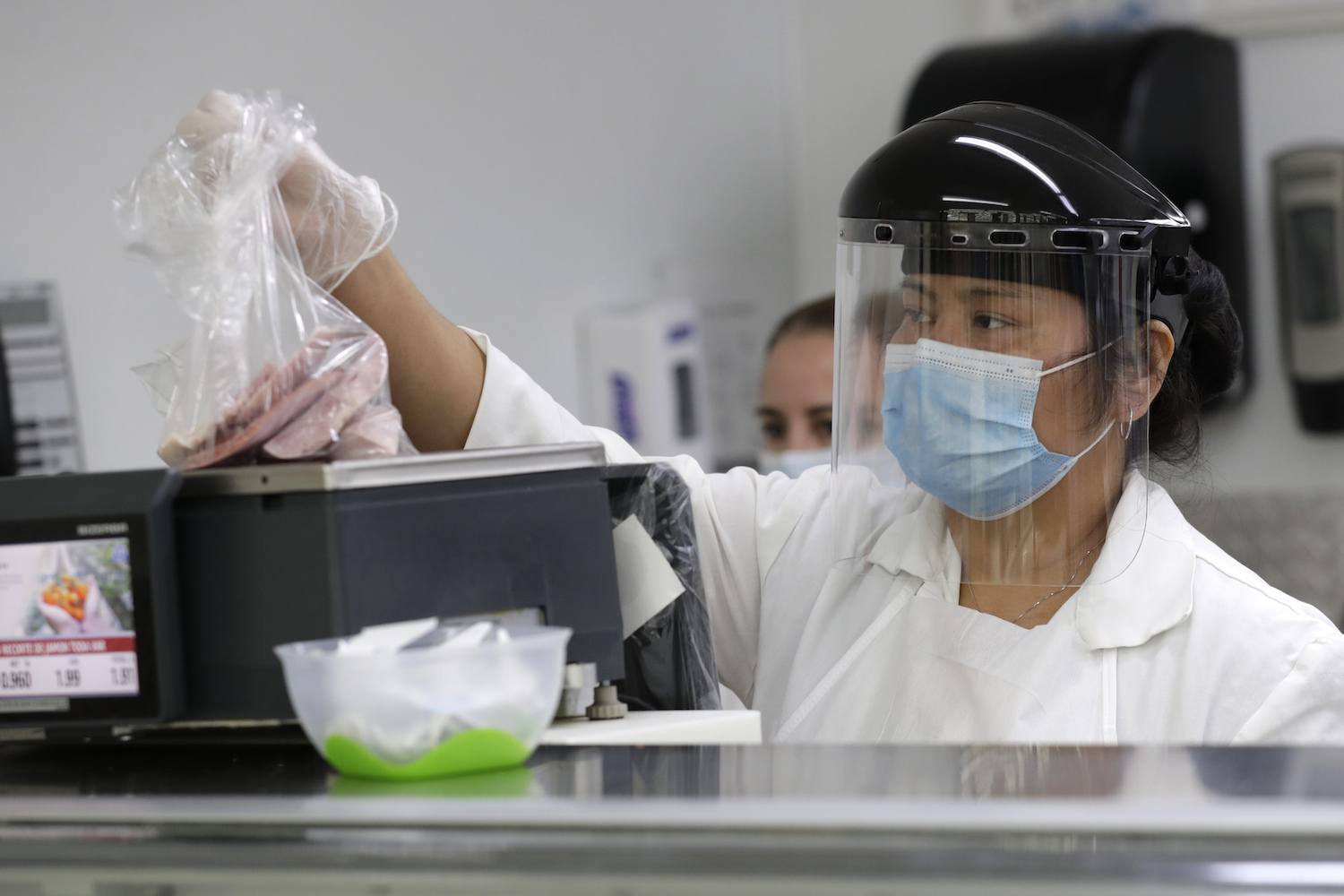 Angelica Modica wears PPE while working at deli counter at the Presidente Supermarket, in Hialeah, Florida. Minimum wage. November 2020