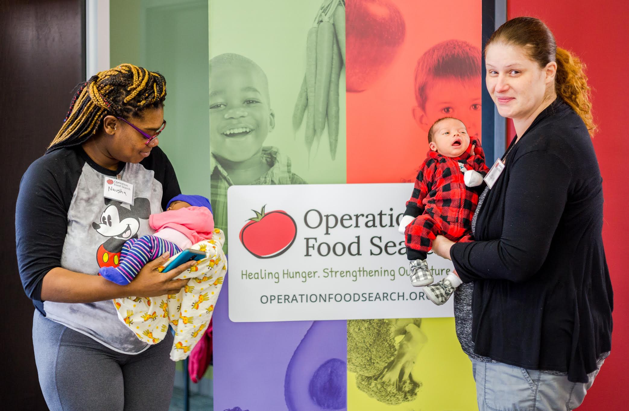 Two mothers holding their newborn babies at Operation Food Search in St. Louis. November 2020