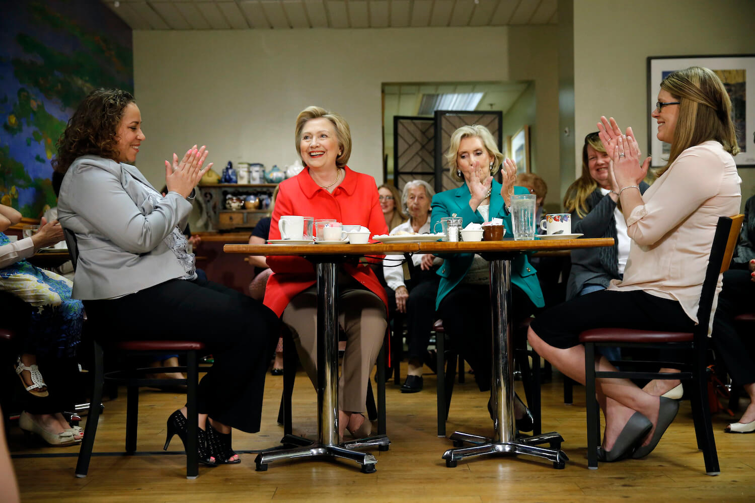 Hillary Clinton sits at a table drinking tea with Lilly Ledbetter and other women. November 2020