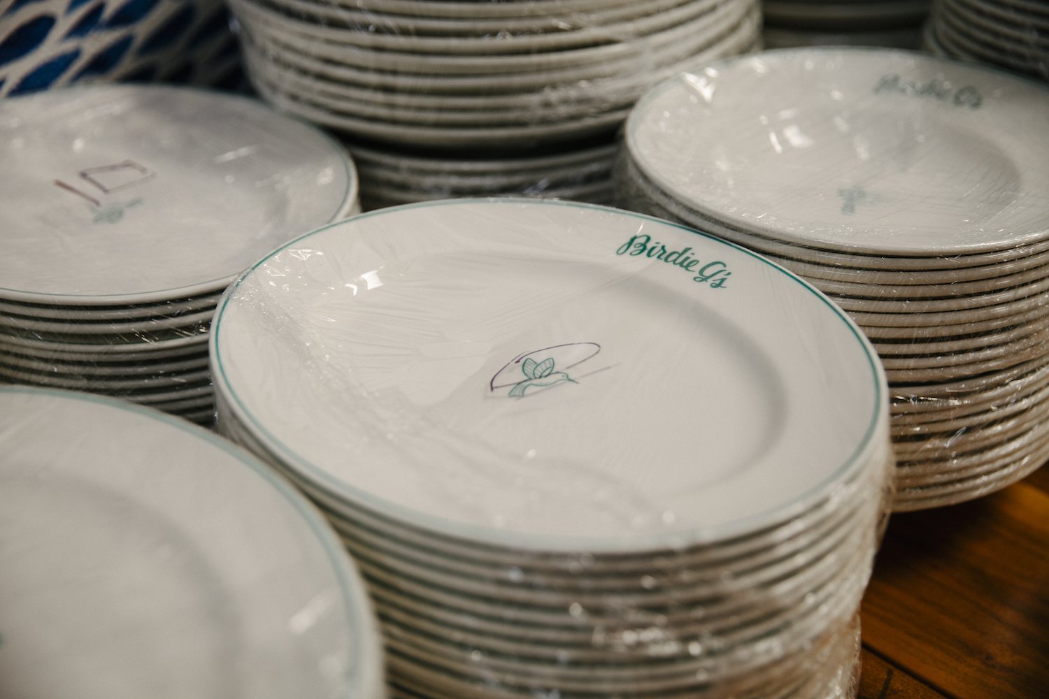 A stack of plates with the Birdie G's logo. December 2020