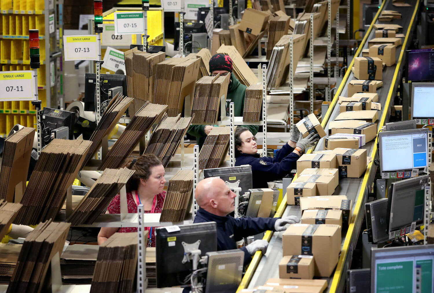 Staff label and package items inside one of the largest Amazon warehouses. January 2021