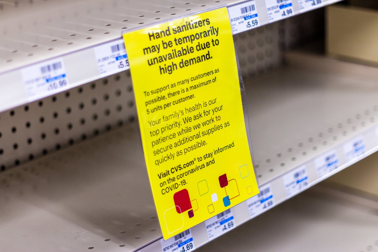 Empty shelves for hand sanitizer with a sign noting they may be temporarily unavailable due to high demand at a CVS in Arlington, VA during COVID-19 outbreak