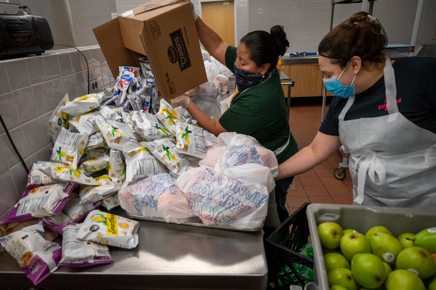 Two cafeteria women work to pack grab and go meals for students during Covid-19. January 2021