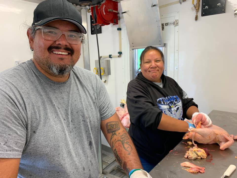 Nick Hernandez and Lisa Iron Cloud process chickens in the Makoce Agriculture Development mobile poultry unit. February 2021