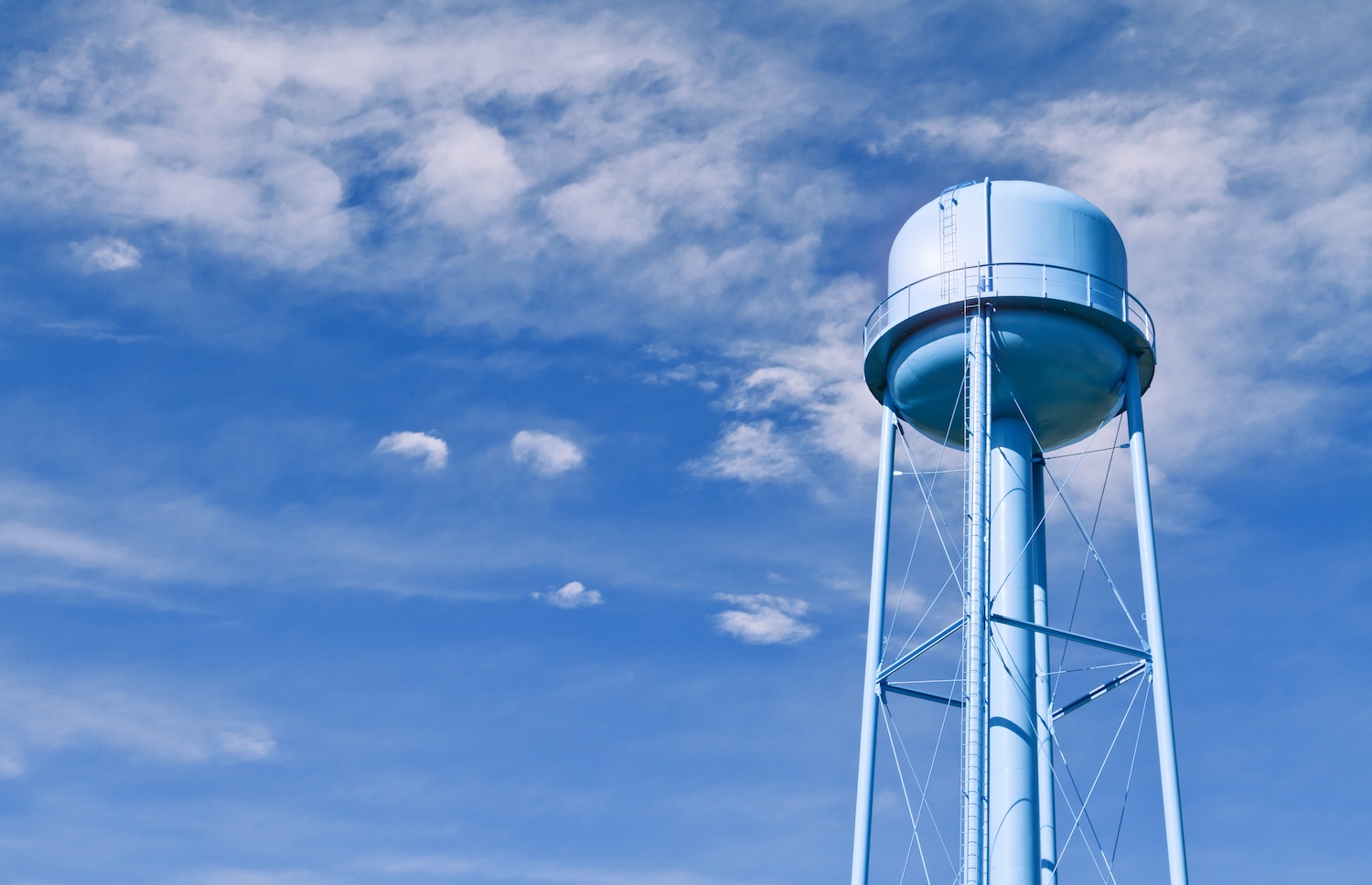 A city water tower set against a blue sky. March 2021