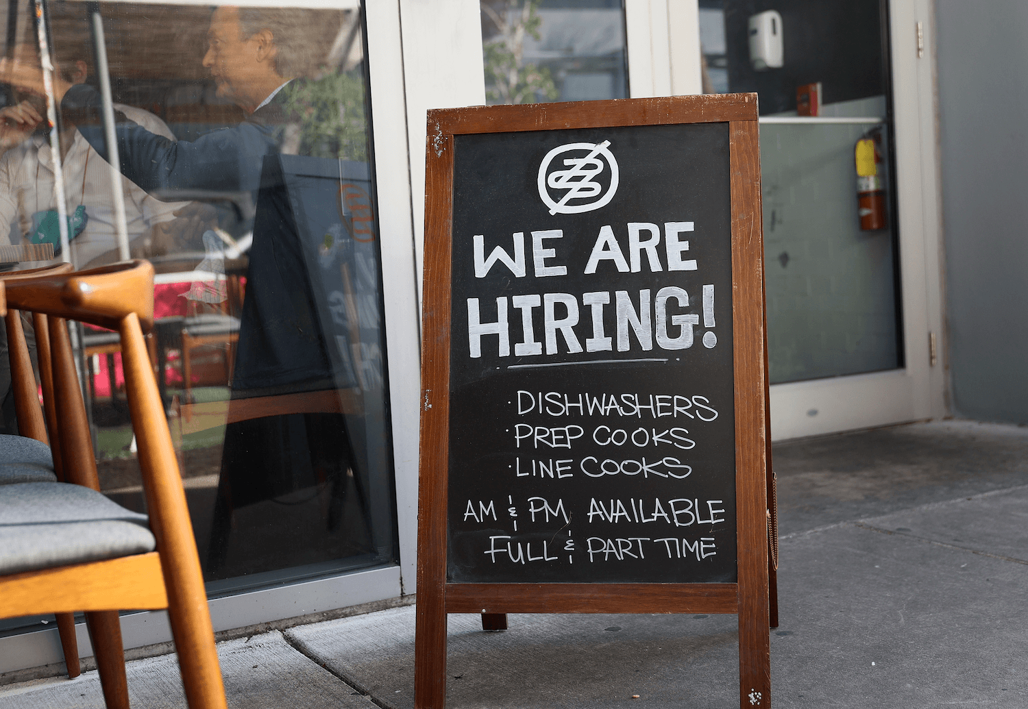 We are hiring dishwashers, prep cooks, line cooks written on a chalkboard sign with a wooden frame, Miami, FL. April 2021