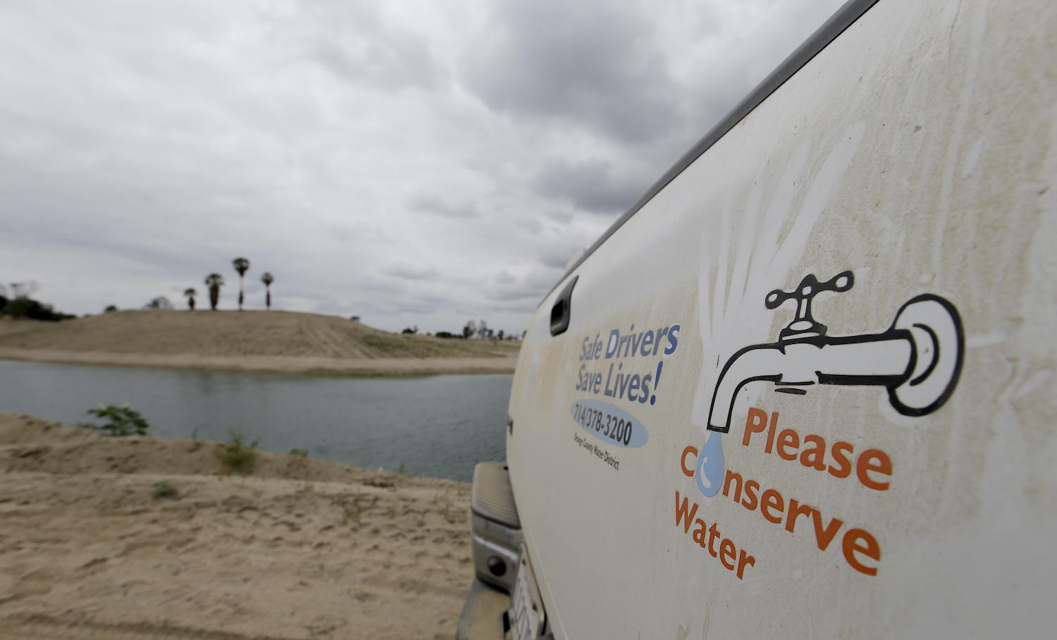 A decal on the dusty tail gate of a Orange County Water District truck asks people to conserve water near their recharge facility on Wednesday, May 6, 2015 in Anaheim, Calif. May 2021