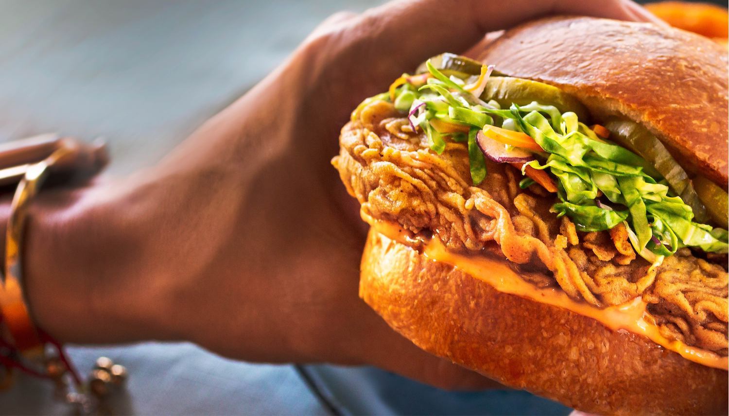 Mock chicken sandwich in hand from Upside Foods. May 2021