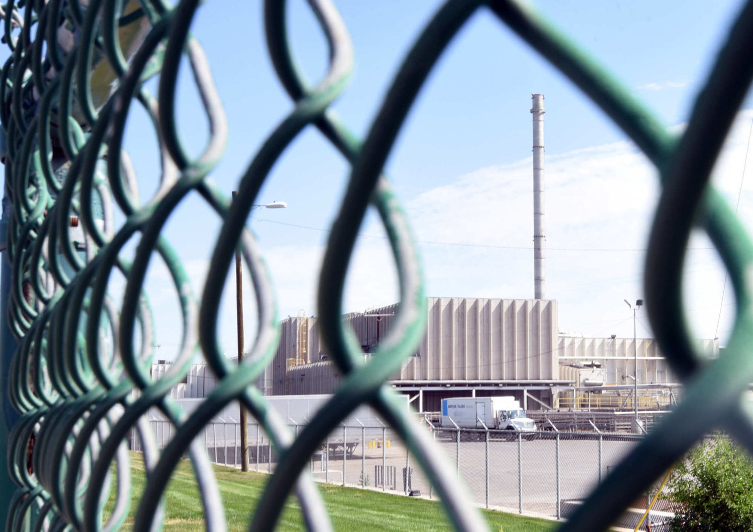 A chain link fence separates the JBS facility from the nearby highway.