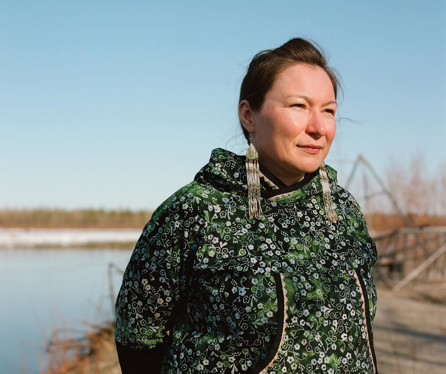 Eva Dawn Burk stands on the bank of the Tanana River in late April in her home village of Nenana, Alaska. Burk is a graduate student at the University of Alaska Fairbanks, who is developing biomass-heated greenhouses for rural Native communities.