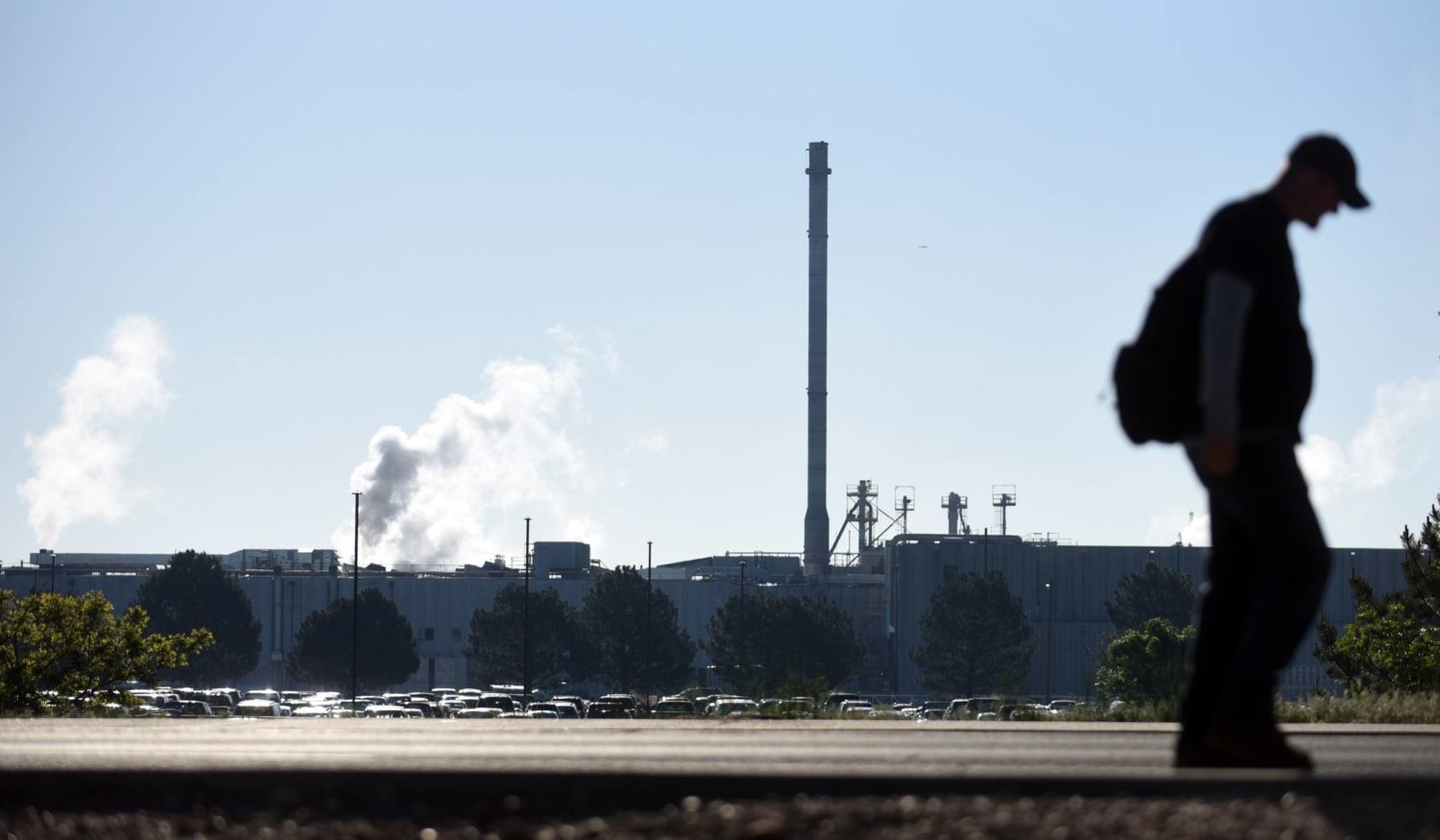 A man is silhouetted as he walks by the JBS facility on Friday, June 4 2021.