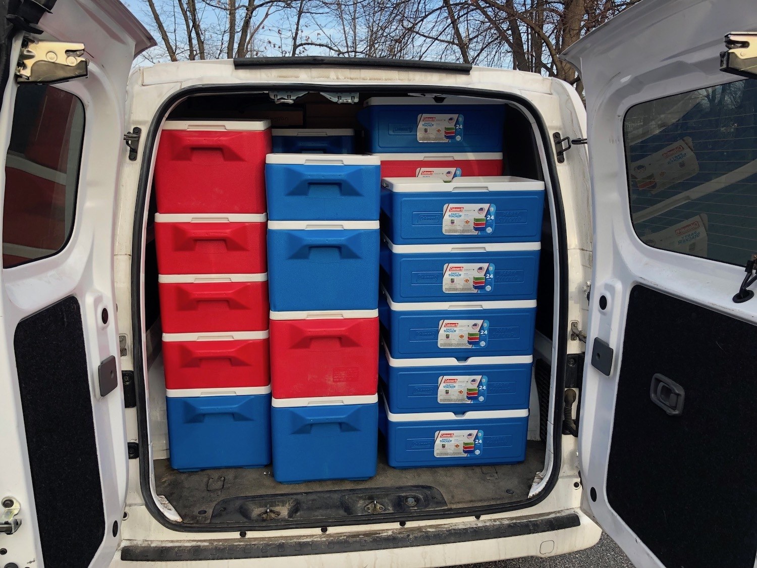 A van filled floor to ceiling with red and blue coolers for delivery. 2020