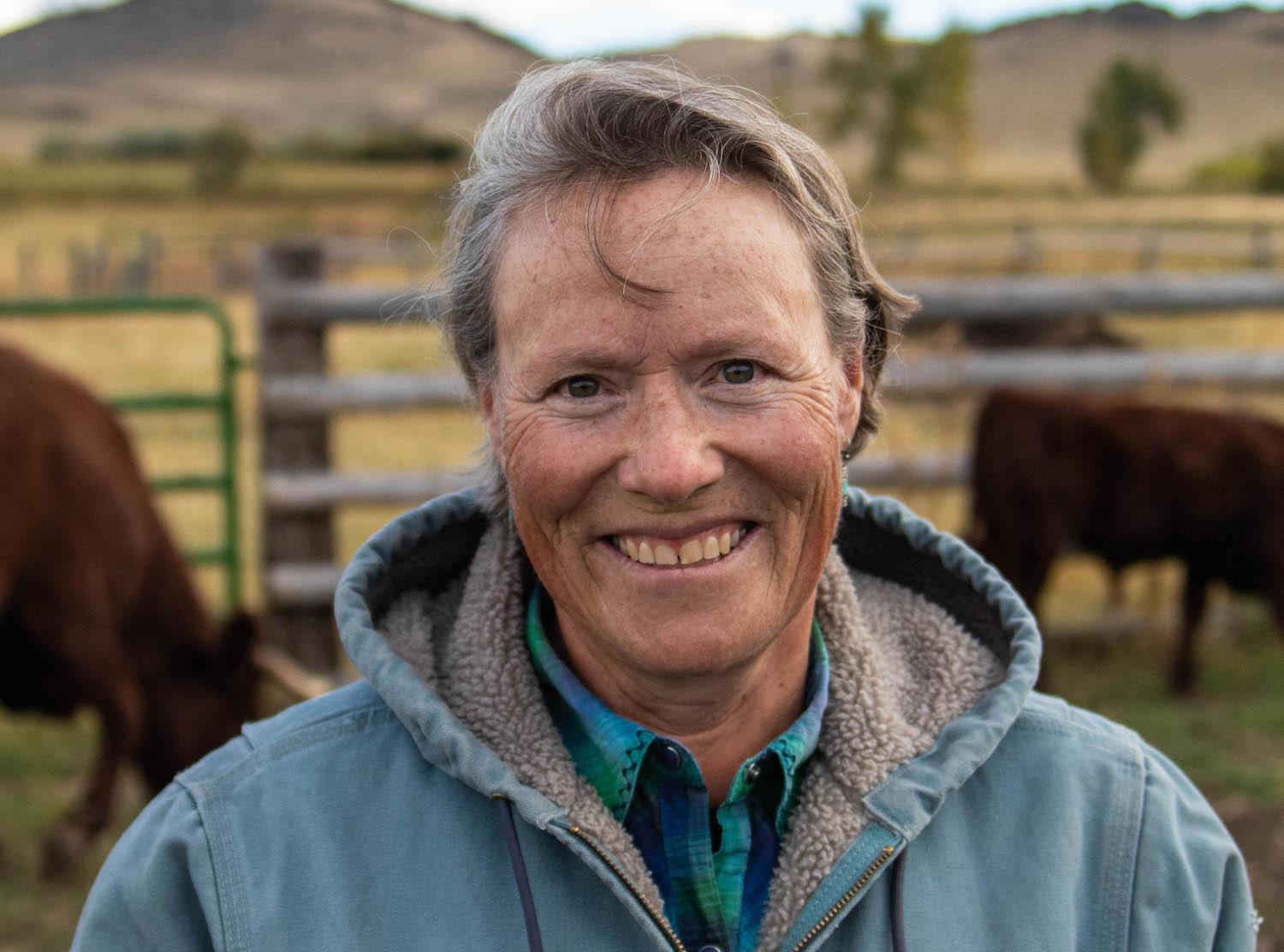 A profile of Jenny Kahrl in front of her cattle. July 2021