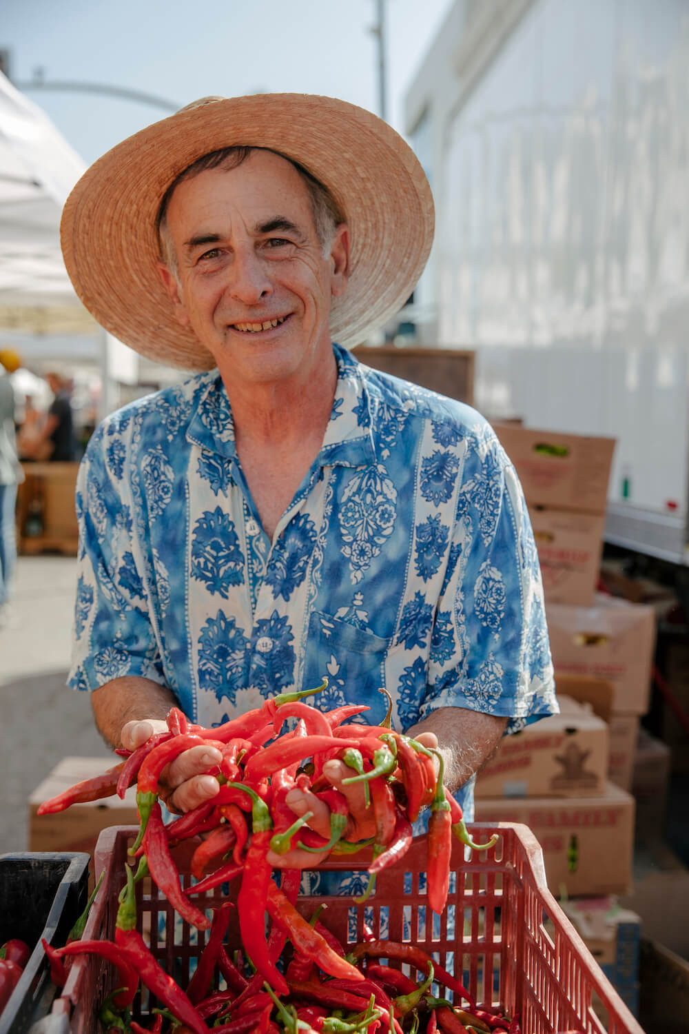 Alex Weiser holds a handful of red peppers. August 2021