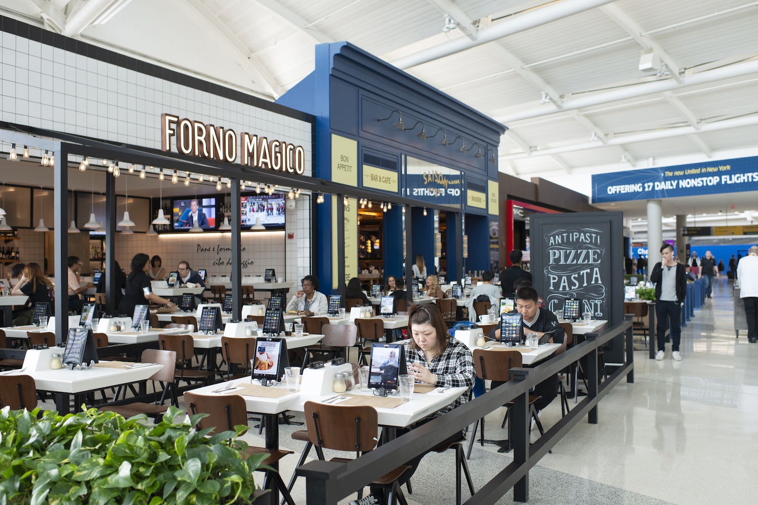 Travelers dining at Forno Magico restaurant in Newark International Airport, Newark, New Jersey, USA. (Newark, USA - May 11, 2017.