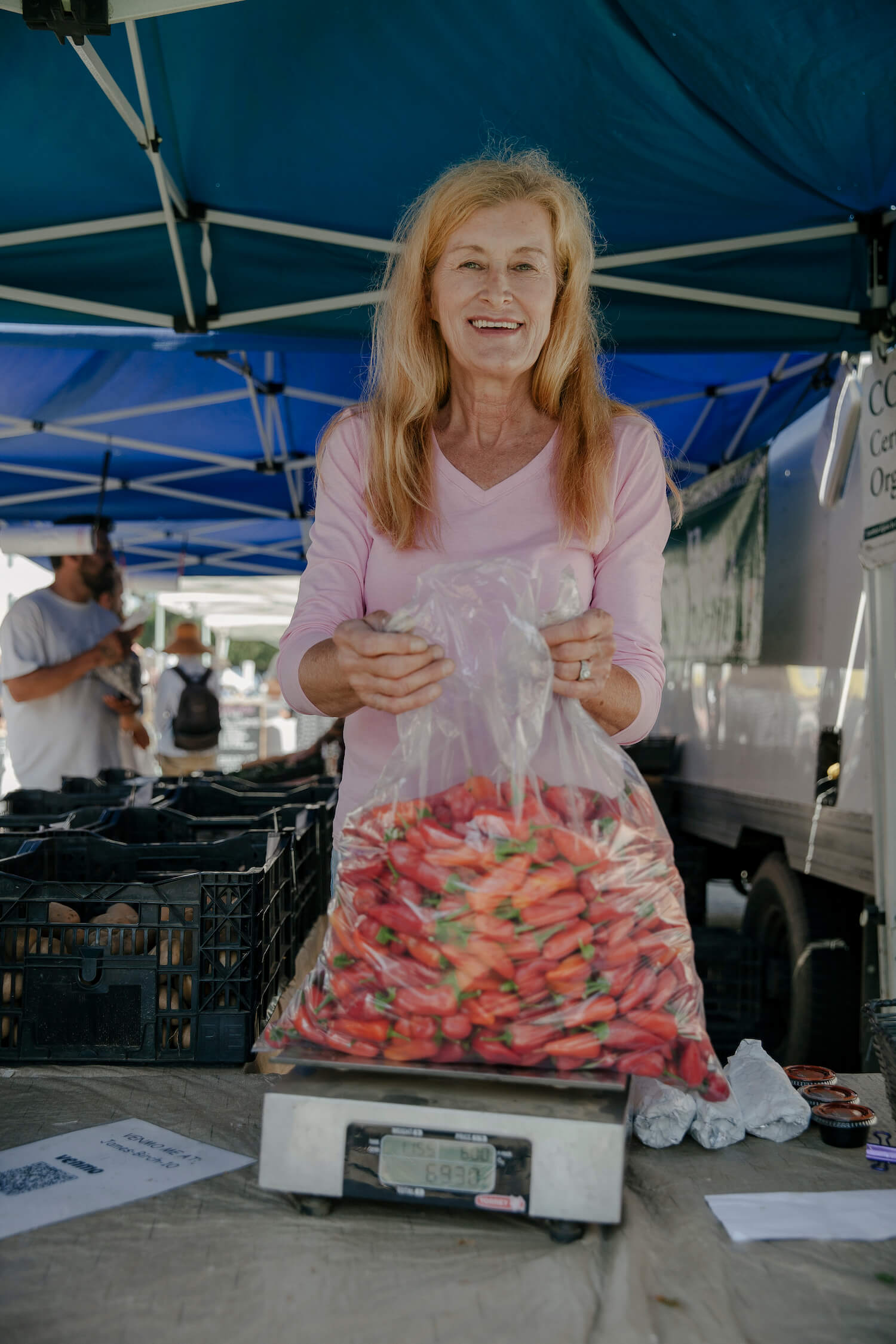 Portrait of Dawn Birch weighing peppers at her farm's stand. August 2021