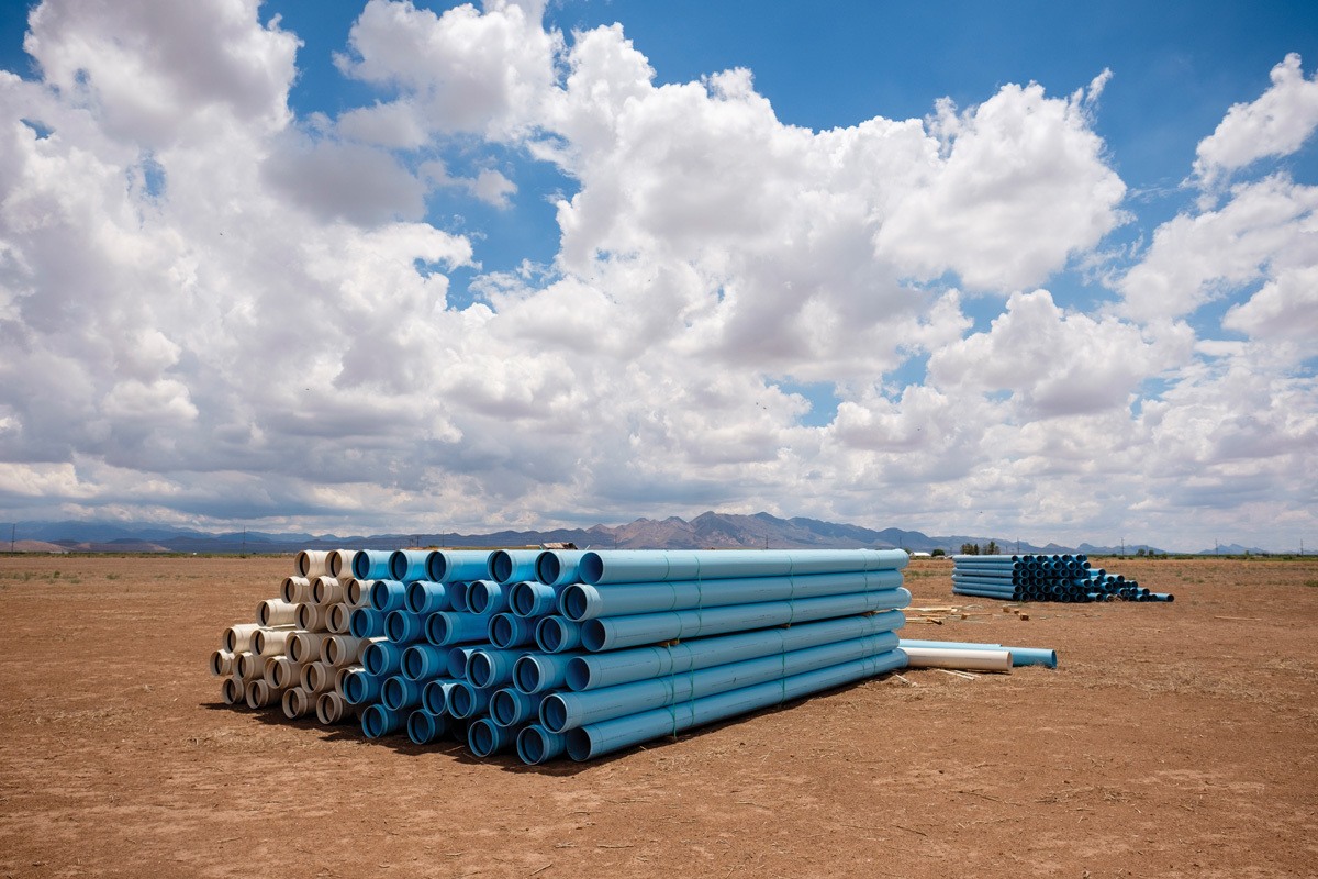 Water pipes are piled near a new pivot irrigation system on land recently acquired by Riverview LLP in Elfrida, Arizona. August 2021