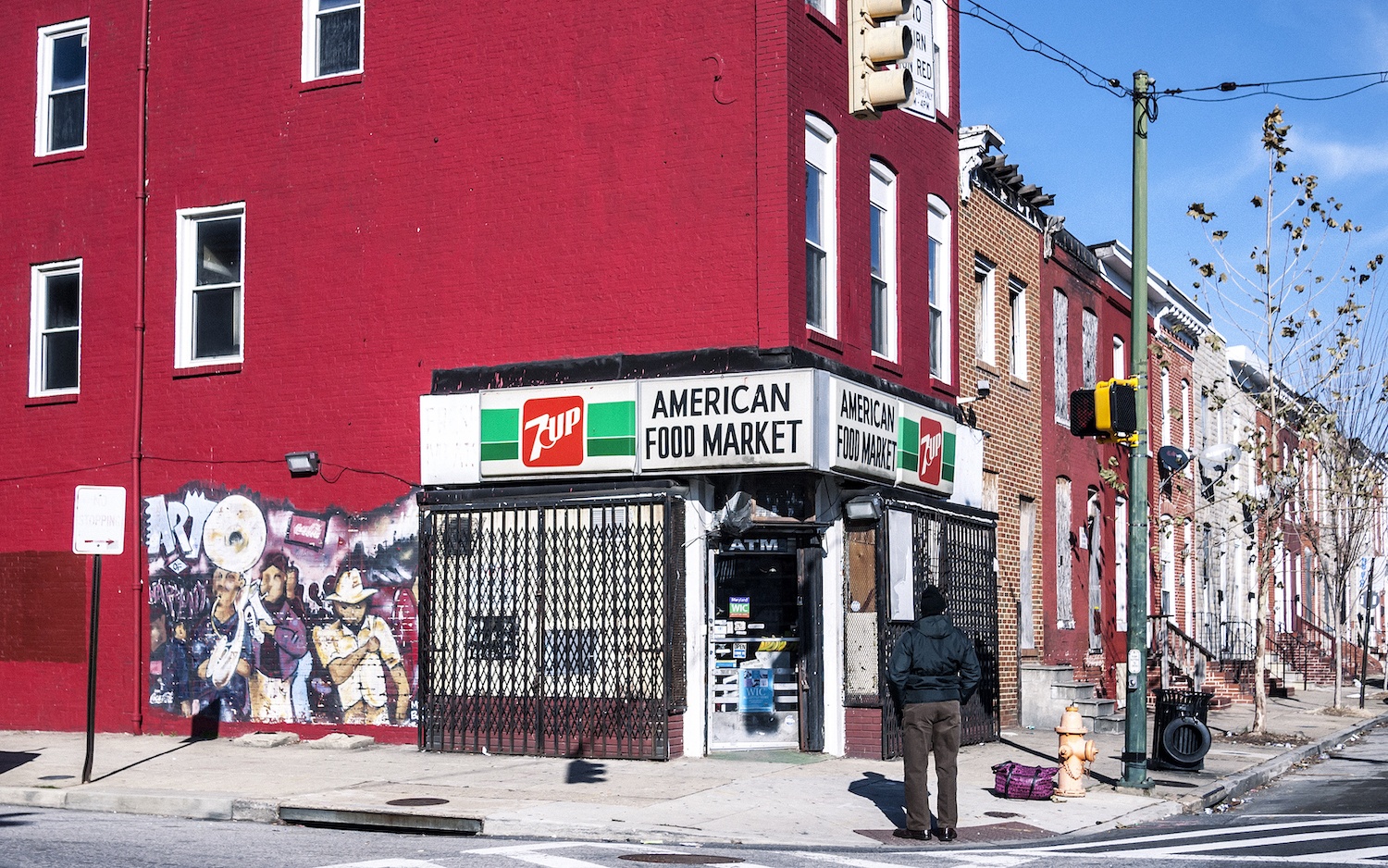 Baltimore, Maryland, USA - December 20, 2016: Man standing infront of typical corner shop in East Baltimore.