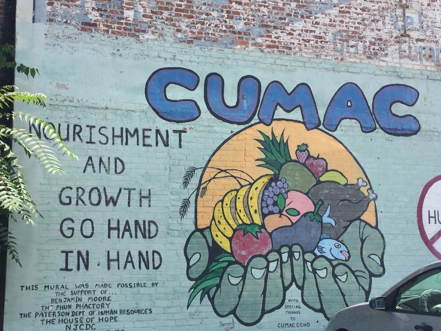 CUMAC mural on brick wall. It reads, Nourish and growth go hand in hand. September 2021