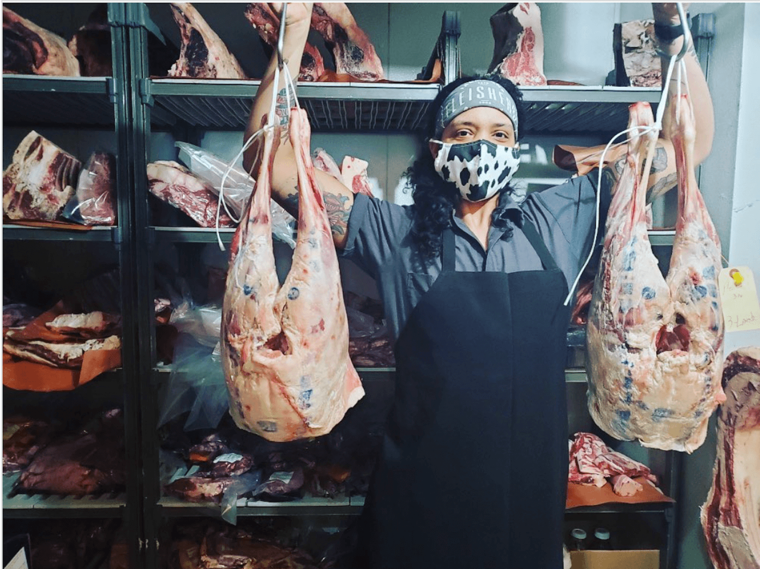 Jade Golden standing in a meat locker with hanging carcasses. September 2021