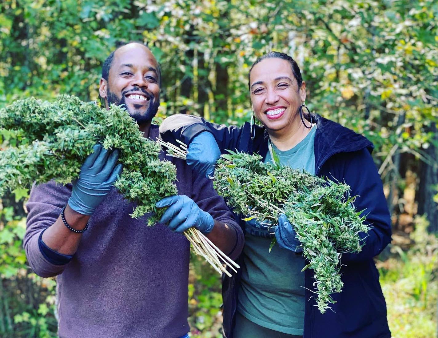 Roy Pope, left, and Mia Darden, right, holding harvested hemp at Kind Origins Pharms in Toney, Alabama. Sept. 2021