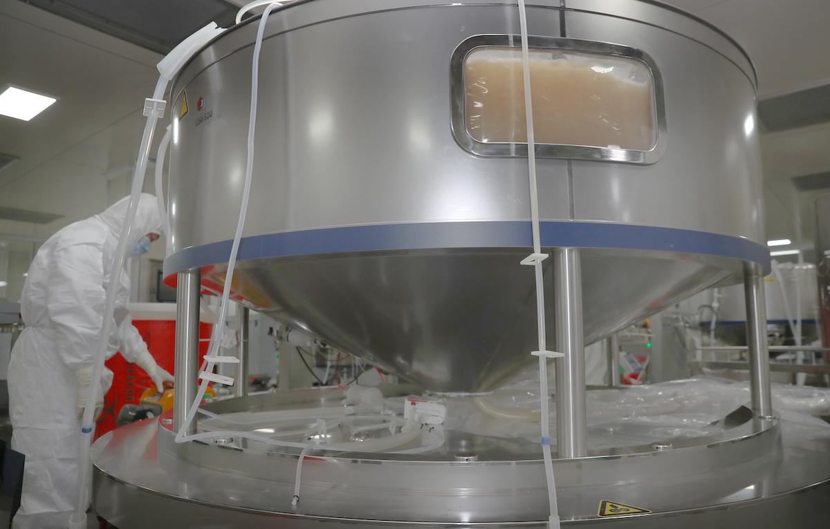 a researcher helps attends a tank of growth media to be used for COVID-19 vaccine production in Nantong, China.